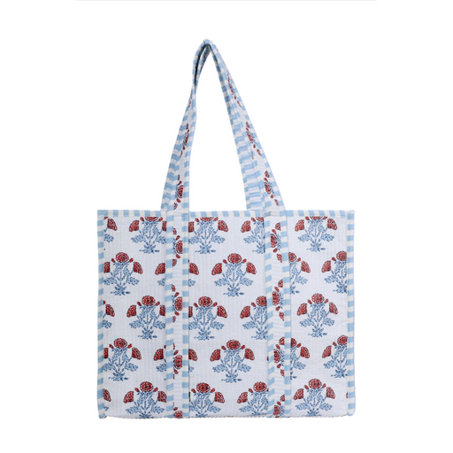 A white woven tote bag with blue and red floral block prints and blue-and-white striped handles, shown against a plain white background.