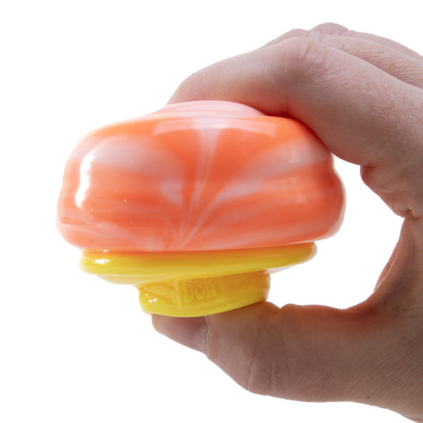 Hand holding a marbled orange and white stress ball with a yellow base on a white background