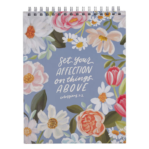 Notebook with floral design and text on a blue background