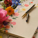 Floral notebook with a decorative pen on a floral background