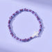 Purple beaded bracelet with a star-shaped charm on a light purple background