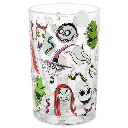 A clear glass tumbler featuring a collage of characters and motifs from Disney's 'The Nightmare Before Christmas,' including Jack Skellington, Sally, Ghostface, and other spooky illustrations, shown on a plain white background.