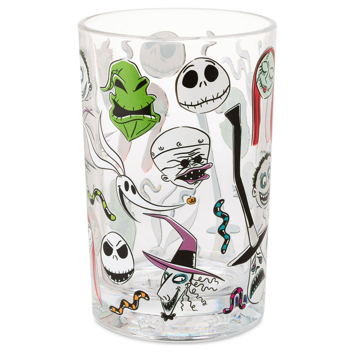 A clear glass tumbler featuring a collage of Jack Skellington and The Nightmare Before Christmas characters, including Jack Skellington, Sally, the Mummy, a ghost, and a witch, printed on a white background.