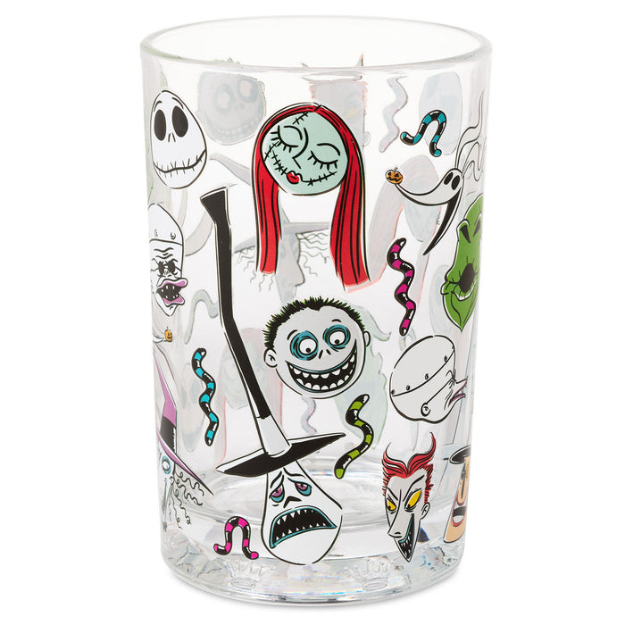 A clear glass tumbler featuring a collage of characters and motifs from 'The Nightmare Before Christmas', including Jack Skellington, Sally, and other iconic illustrations, set against a plain white background.