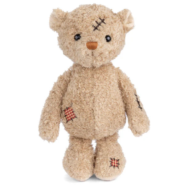 Teddy bear with bandages and stitches on a white background