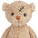 Teddy bear with a bandage on its head against a white background
