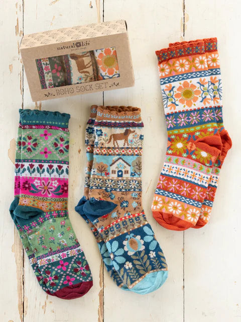 Colorful patterned socks with a box labeled 'Natural Life' on a wooden surface