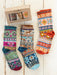 Colorful patterned socks with a box labeled 'Natural Life' on a wooden surface