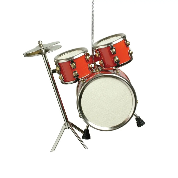 A miniature toy drum set hanging from a silver string, featuring red drums with gold hardware and a white bass drum, set against a plain white background.