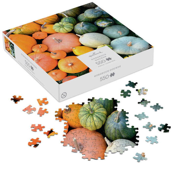 Puzzle box with pumpkin design and scattered puzzle pieces on a white background
