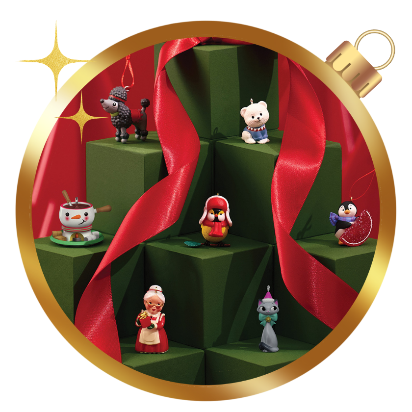 Hallmark Keepsake miniature Christmas ornaments displayed on green gift boxes with festive ribbon.
