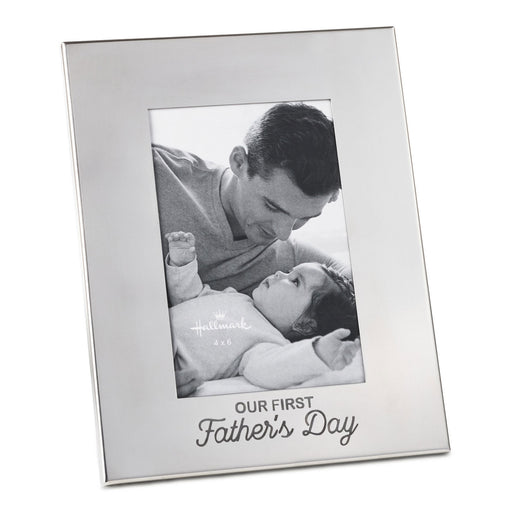 Silver photo frame with 'Our First Father's Day' text, displaying a black and white photo of a man and a baby.