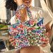 Person holding a colorful patterned bag outdoors