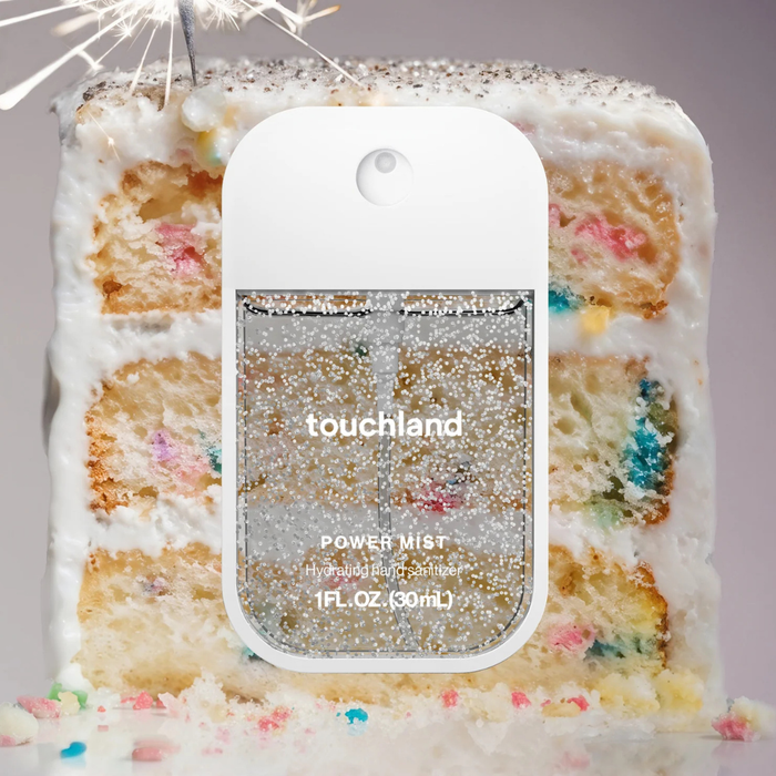 Touchland power mist in front of a colorful cake
