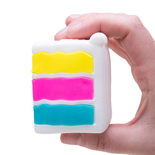 Colorful striped square object held by a hand on a white background