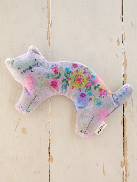 Floral-patterned cat-shaped soft toy on a wooden surface