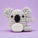 Crocheted koala toy on a purple background