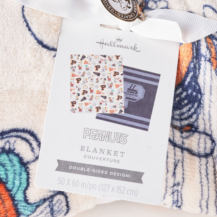 Hallmark Peanuts blanket packaging on a colorful blanket background