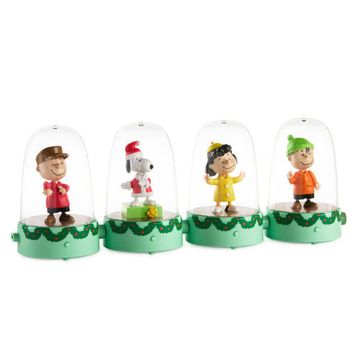 Four small figurines under glass domes on a white background