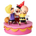 A collectible figurine of the Peanuts characters Charlie Brown, Snoopy, and Woodstock celebrating Halloween on a pink and gold cake-shaped base.
