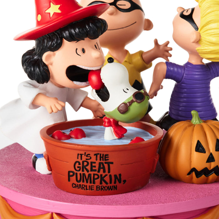 Halloween-themed Peanuts figurines featuring Charlie Brown in a wizard costume splashing Snoopy in a tub labeled 'IT'S THE GREAT PUMPKIN, CHARLIE BROWN,' with a pumpkin and other characters visible against a white background.