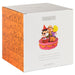 A square white product box for a Peanuts item, showing the front and side panels. The side panel is orange with a repeating black-and-white comic strip pattern, and the front panel is white with the word 'PEANUTS' in gray above a small illustration of characters on a pink platform.