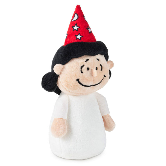 A plush toy figure of a cartoon character with a red party hat decorated with white stars and a crescent moon, black hair, a beige face, and a white dress, isolated on a white background.