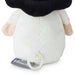Close-up of the back of a plush toy with a black fuzzy top, white body, pale peach arms, and a gray fabric tag reading Hallmark attached near a white ring.