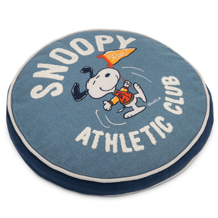 Round blue pillow with Snoopy and 'Snoopy Athletic Club' text on a white background