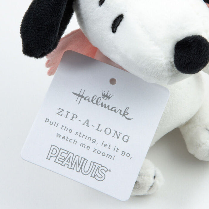 Plush dog toy with a tag featuring the Hallmark logo and 'Peanuts' branding on a white background.