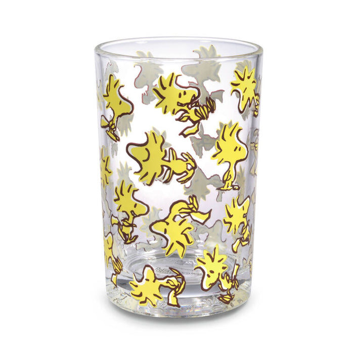 Clear glass tumbler with yellow bird pattern on a white background