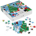 A 550-piece jigsaw puzzle box labeled 'Playful Penguins - Christmas Mart Fun' shown open with several loose puzzle pieces scattered in front. The box and assembled pieces feature a colorful winter holiday scene with penguins, a Christmas tree, snow, and festive decorations.