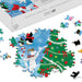 A 550-piece Christmas-themed jigsaw puzzle box and scattered puzzle pieces on a white background. The assembled puzzle shows penguins, a white ram, and a decorated Christmas tree in winter colors.