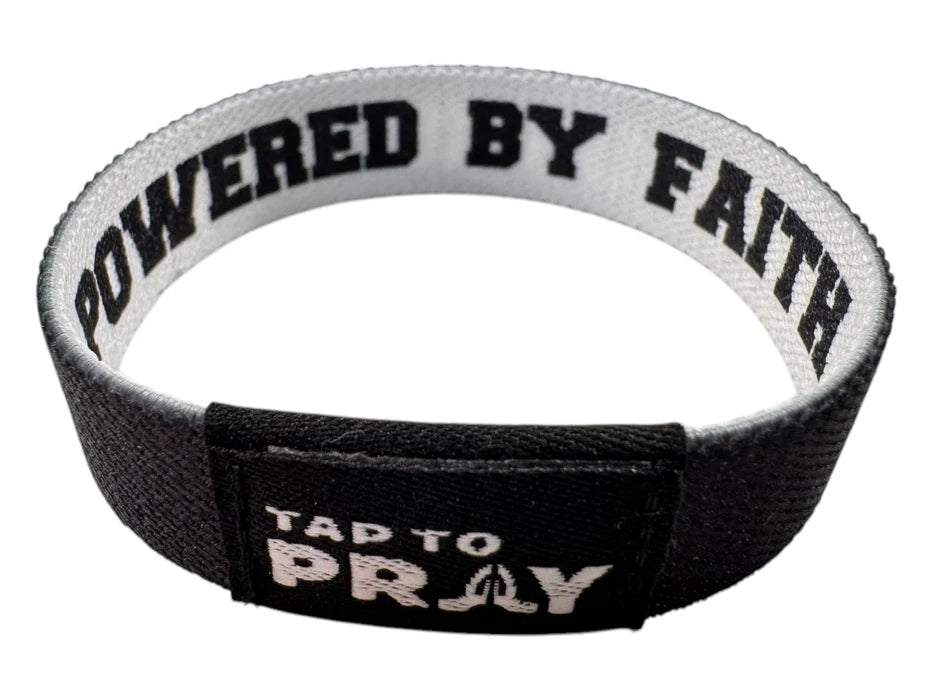 Black and white wristband with 'Powered by Faith' and 'Tap to Pray' text on a white background