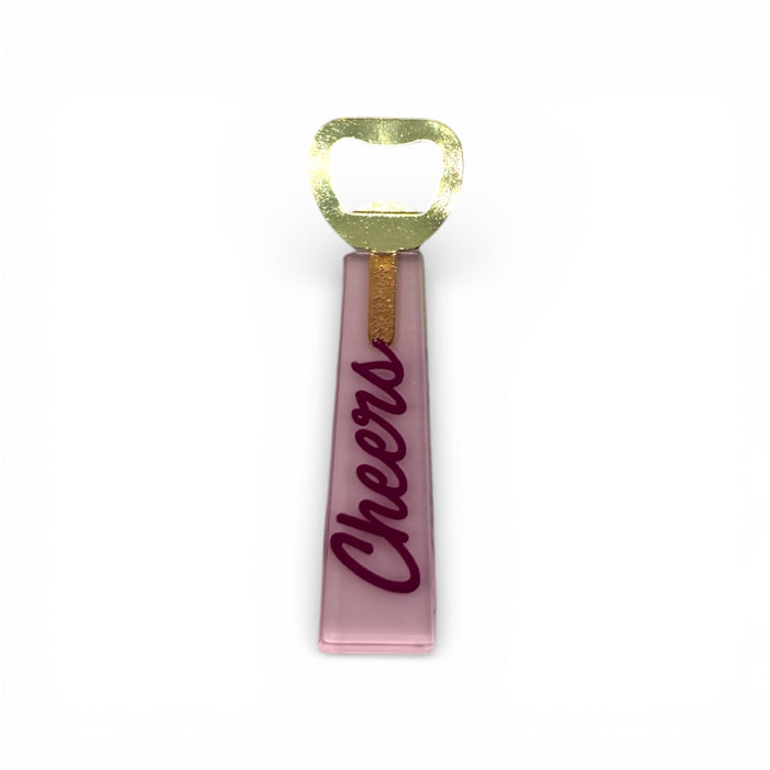 Pink bottle opener with 'Cheers' text and gold accent on a white background