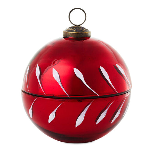 Red glass ornament with white abstract designs on a white background