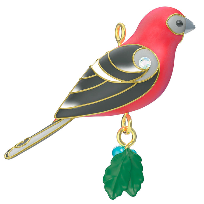 Colorful bird-shaped ornament with a green leaf charm on a white background