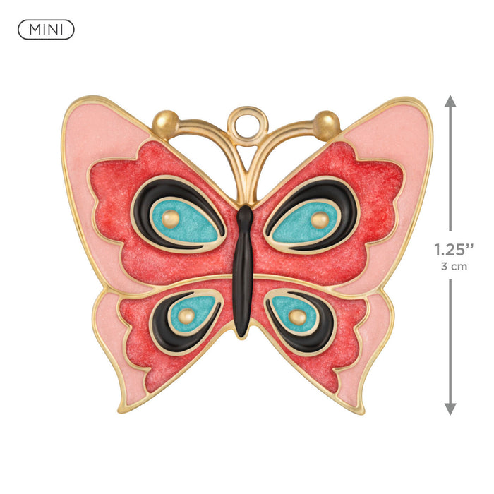 Butterfly-shaped pendant with gold frame, red wings, and blue centers on a white background.