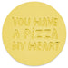 A round gold token with the phrase 'YOU HAVE A PIZZA MY HEART' embossed in raised letters, shown on a plain white background.