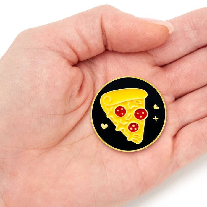 Pizza-themed pin held in a hand on a white background