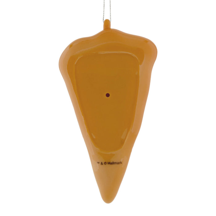 An orange plastic Christmas ornament shaped like a melting carrot, hanging from a thin metal string against a plain white background.