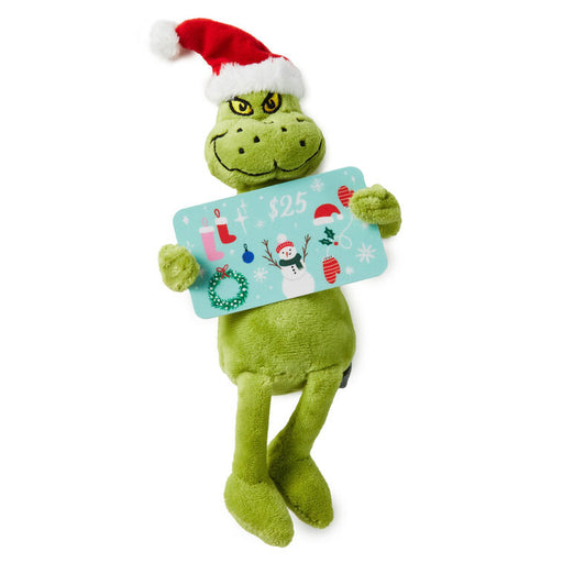 Green plush toy with a Santa hat holding a gift card on a white background