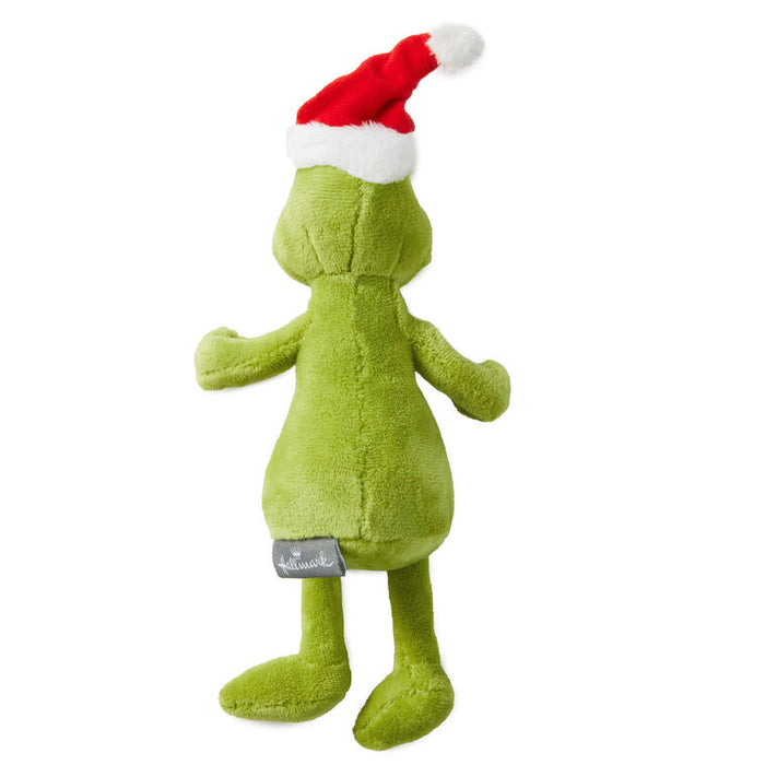 Green plush toy with a red and white Santa hat on a white background