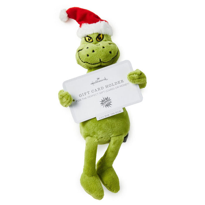 Green plush toy with a Santa hat holding a gift card holder on a white background