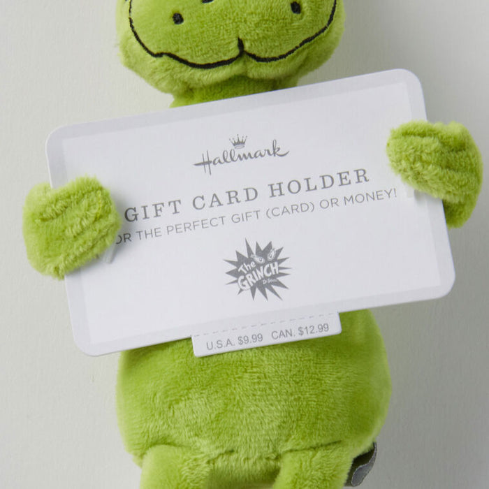 Green plush toy holding a Hallmark gift card holder with branding.