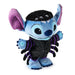 A Stitch plush toy dressed as a spider, featuring a blue body, purple ears and accents, a black spiderweb-patterned body, and a black fuzzy head with three small eyes.