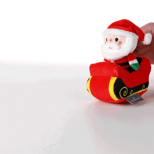 Plush toy of Santa Claus in a sleigh on a white background