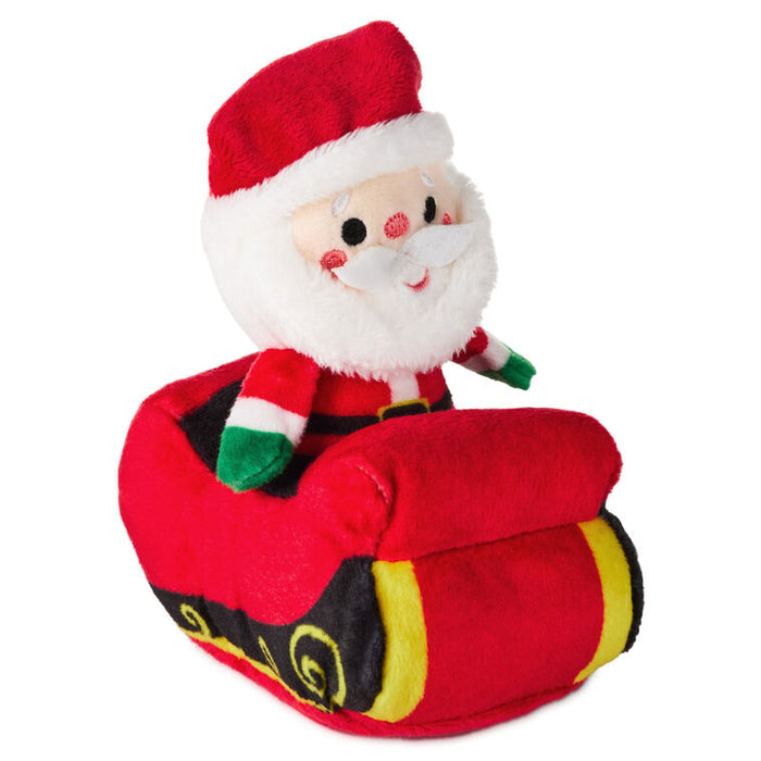 Plush toy of Santa Claus on a red car with a white background