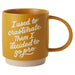 Yellow mug with white text on a white background