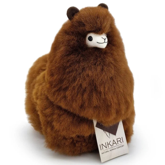 A brown alpaca plush toy with a white face and black embroidered eyes and mouth, sitting on a white background with an Inkari tag attached.